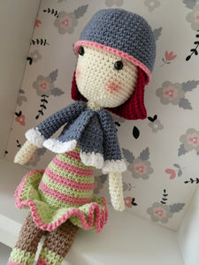Madeline the Crochet doll in a striped dress in a display box